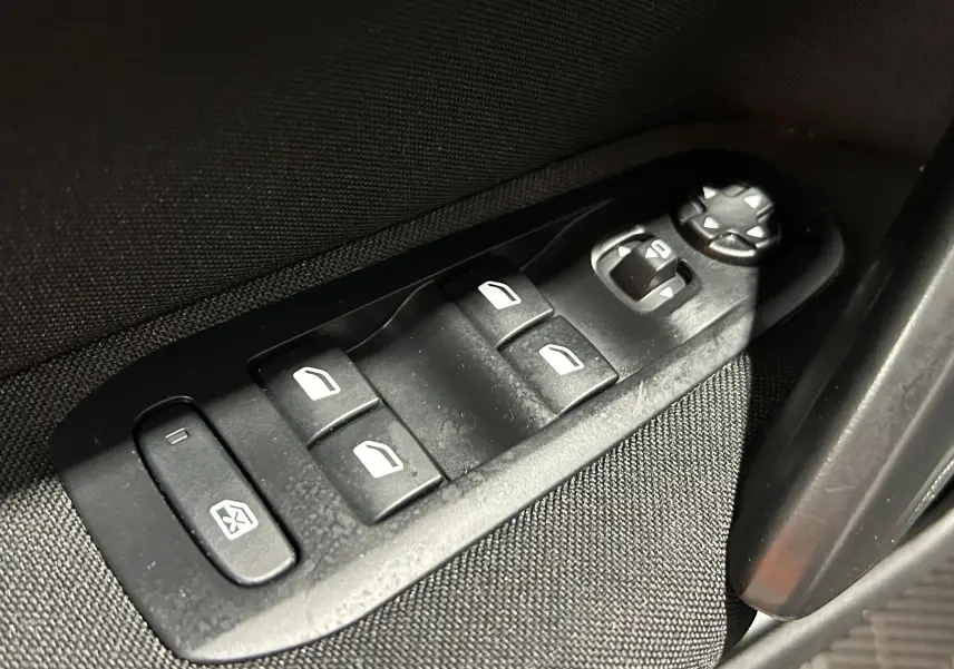 Gros plan sur les commandes de lève-vitres et réglage des rétroviseurs côté conducteur d'une Peugeot 308 gris 2021.