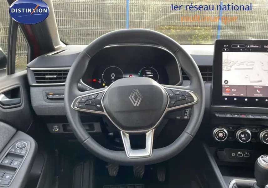 Vue intérieure centrée sur le volant multifonction de la Renault Clio 2025, avec tableau de bord numérique et écran tactile.