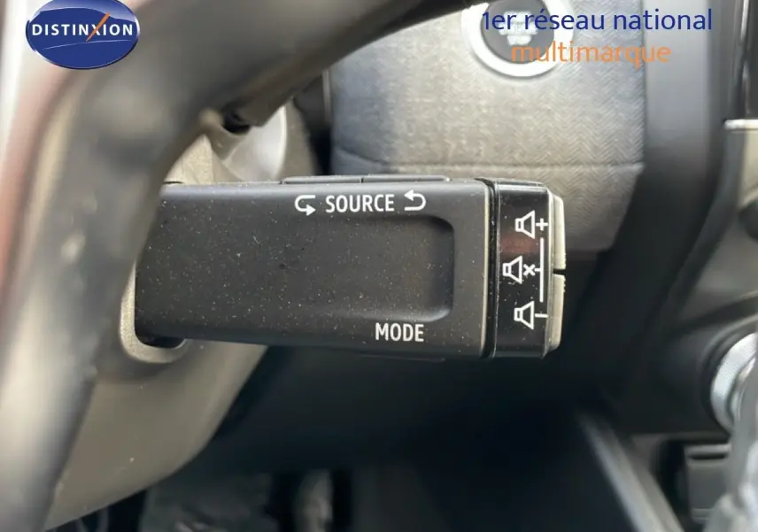 Gros plan sur la commande au volant de la Renault Clio 2025, mettant en valeur les boutons source et mode.