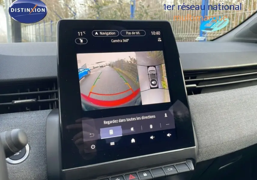 Vue intérieure du tableau de bord de la Renault Clio rouge, avec écran tactile affichant la caméra 360° en marche.