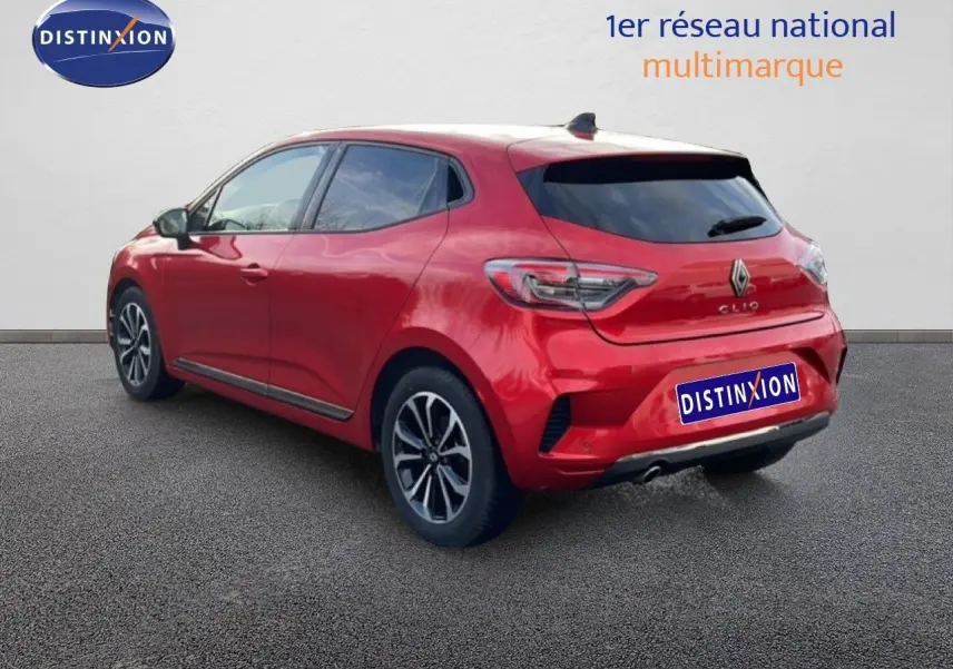 Vue 3/4 arrière droite d'une Renault Clio 2025 rouge désir métal avec jantes alliage et vitres teintées.
