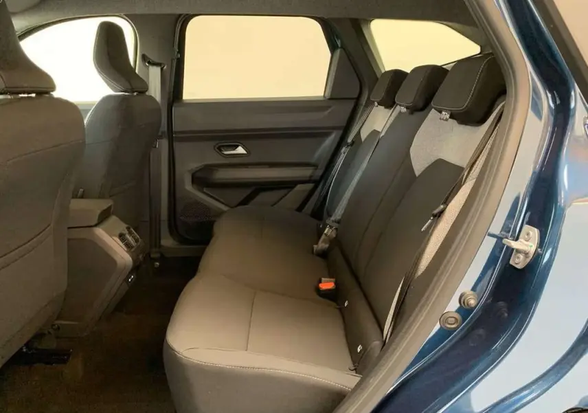 Vue côté droit de la banquette arrière grise du Dacia Bigster Hybrid 155 Journey Plus bleu indigo avec porte ouverte.