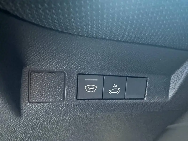 Gros plan sur les boutons de commande noirs du hayon et dégivrage arrière dans l'habitacle du Citroën C5 Aircross 2026.
