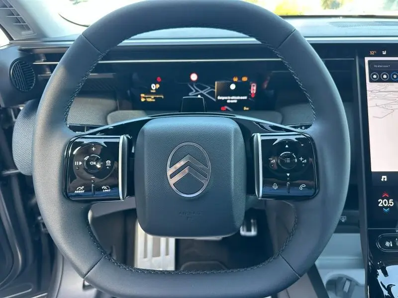 Vue rapprochée du volant noir multifonction du Citroën C5 Aircross 2026 avec tableau de bord numérique et écran tactile.
