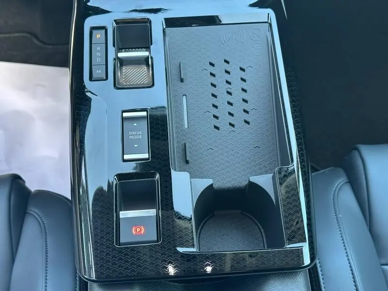 Vue plongeante sur la console centrale noire brillante du Citroën C5 Aircross 2026 avec commandes de boîte auto et porte-gobelets.