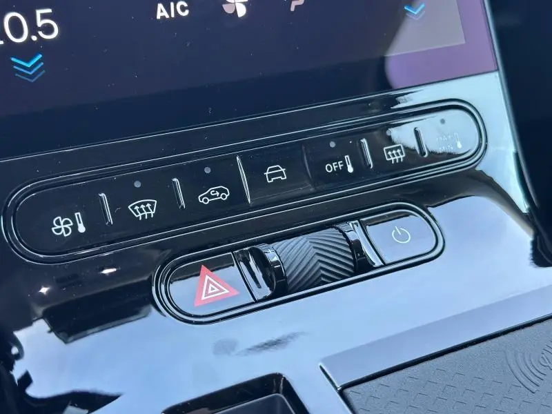 Gros plan sur la console centrale noire brillante du Citroën C5 Aircross 2026, montrant les boutons de climatisation et d'alerte.