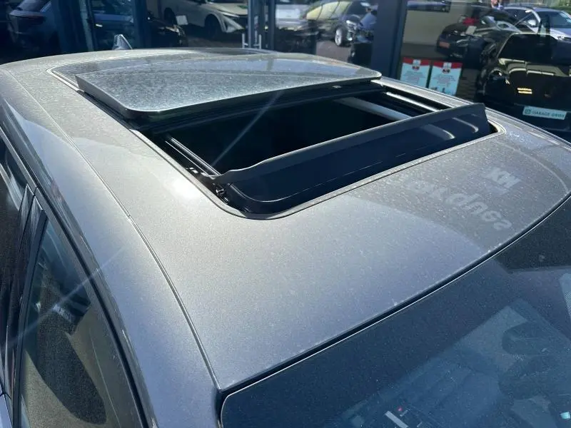 Toit ouvrant panoramique ouvert vu en plongée sur un Citroën C5 Aircross gris métallisé côté gauche.