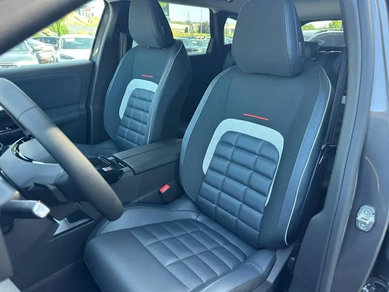 Vue intérieure des sièges avant en tissu bleu et cuir noir du Citroën C5 Aircross 2026, avec accoudoir central.