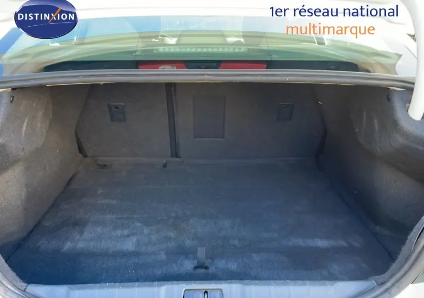 Coffre ouvert de la Peugeot 508 blanche de 2012, vue intérieure montrant un espace de chargement propre et spacieux.
