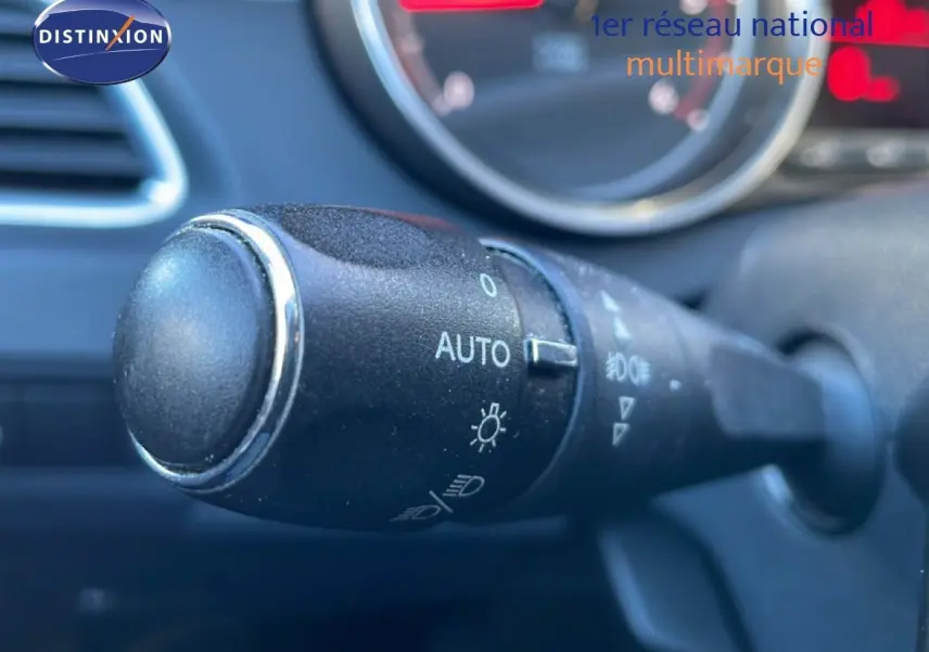 Gros plan sur la commande des phares automatique dans l'habitacle d'une Peugeot 508 blanche de 2012.