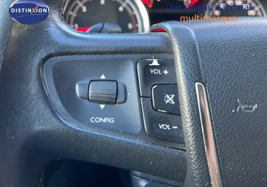 Détail du volant avec commandes de volume et configuration sur Peugeot 508 blanc, tableau de bord en arrière-plan.