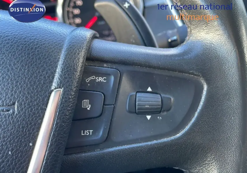 Gros plan sur les commandes au volant noir d'une Peugeot 508 blanche, version 1.6 E-HDI 115CH de 2012.