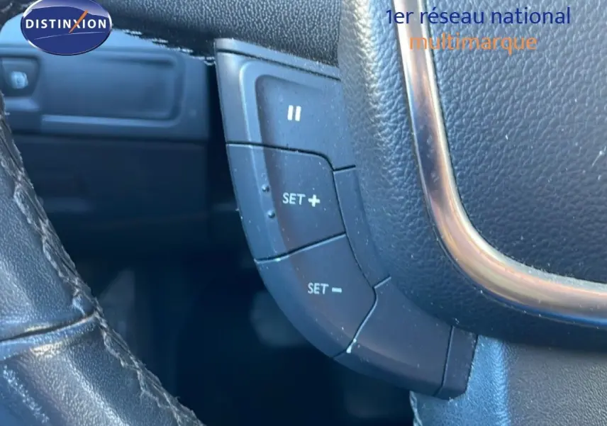 Détail du volant en cuir noir avec commandes de régulateur de vitesse sur une Peugeot 508 blanche de 2012