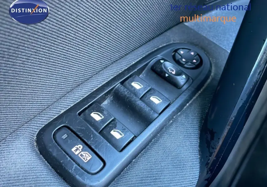 Gros plan sur les commandes des vitres électriques côté conducteur d'une Peugeot 508 blanche de 2012.