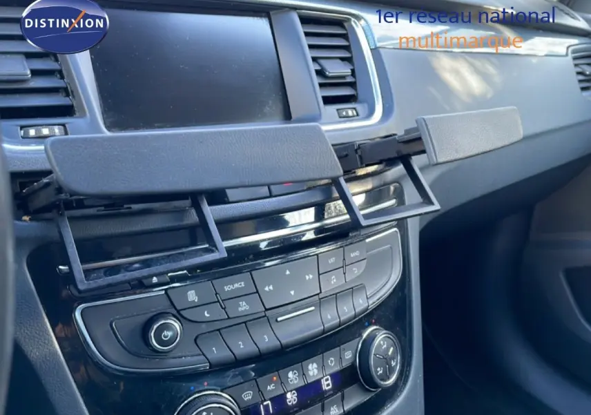 Détail de la console centrale noire avec écran et commandes climatisation d'une Peugeot 508 blanche de 2012
