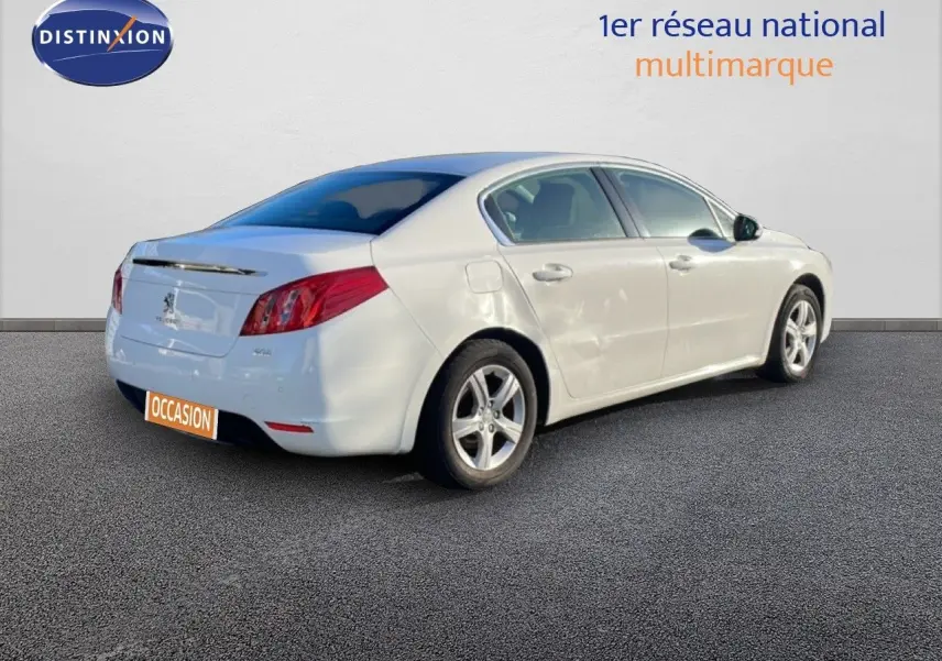 Peugeot 508 blanche vue de trois quarts arrière côté droit, avec jantes alliage et carrosserie lisse.