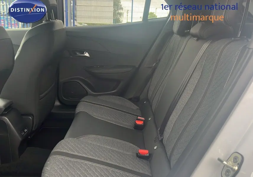 Vue latérale droite de l'habitacle arrière d'une Peugeot 2008 blanche, sièges tissu noir et gris avec surpiqûres blanches.