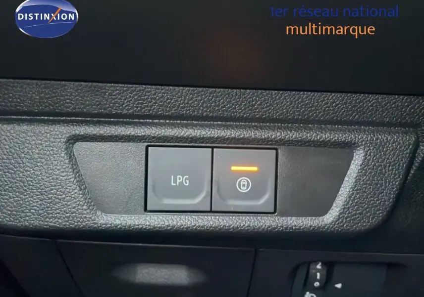 Gros plan sur les boutons de commande LPG et verrouillage intérieur du tableau de bord d'une Dacia Jogger vert cèdre métal.