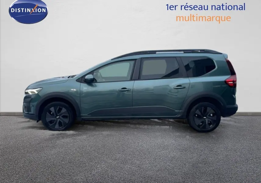 Vue latérale droite d'un Dacia Jogger 2025 vert cèdre métallisé avec jantes noires et toit noir.