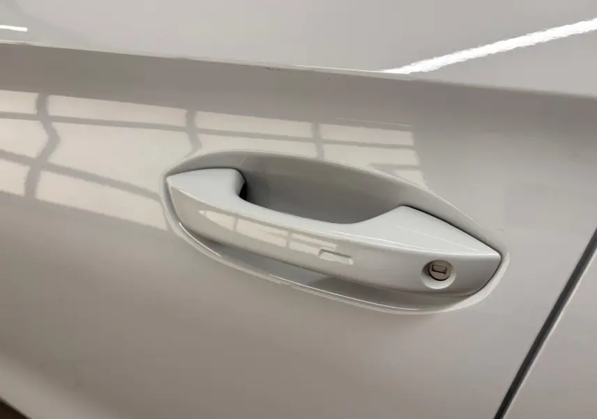 Poignée de porte côté gauche de la CUPRA Leon Phase 2 2025 en blanc Nevada métallisé, avec serrure visible.