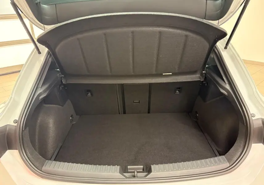 Coffre ouvert vu de l'arrière d'une CUPRA Leon Phase 2 blanc Nevada avec intérieur de coffre noir et tapis plat.