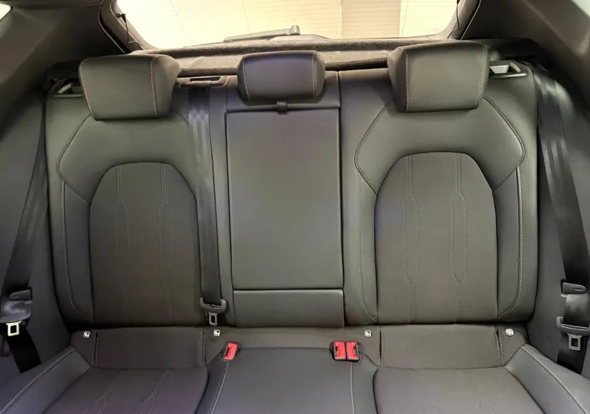 Vue intérieure sur la banquette arrière en cuir noir du CUPRA Leon Phase 2 2025, avec appuie-têtes et ceintures visibles.