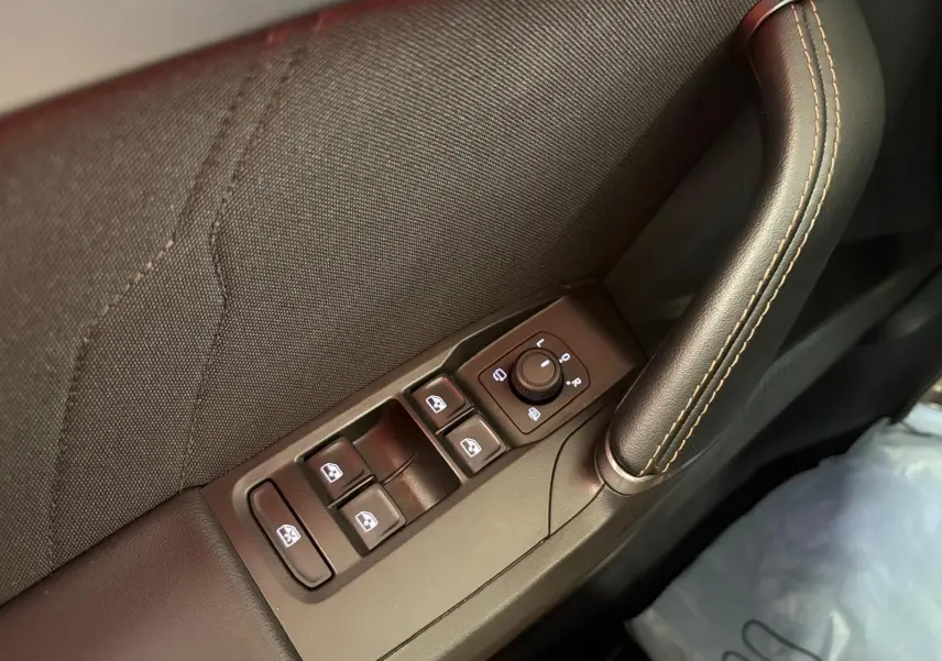 Gros plan sur la commande des vitres et rétroviseurs côté conducteur de la CUPRA Leon blanc Nevada.