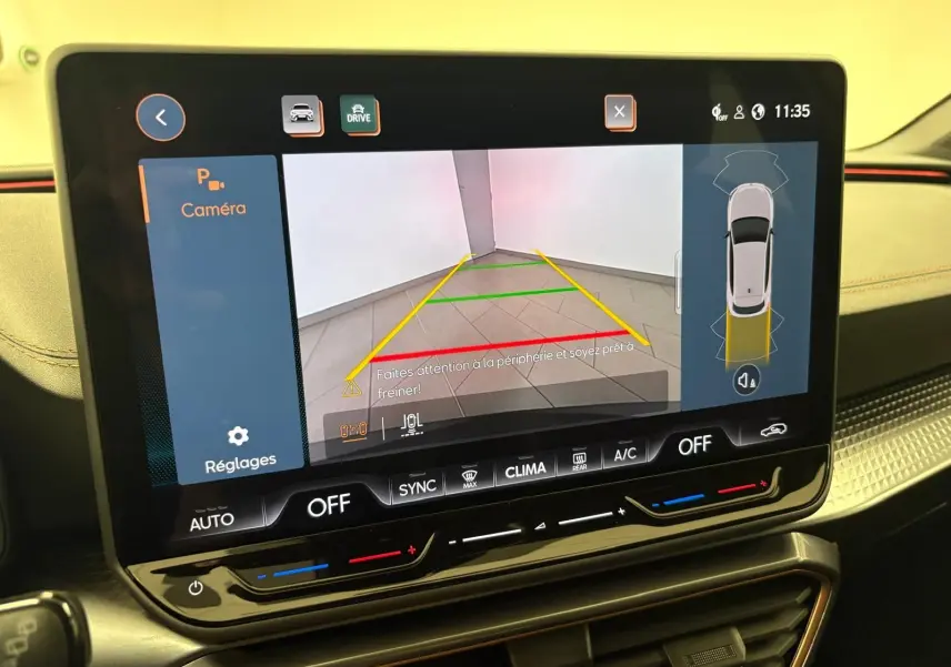 Écran central de la CUPRA Leon Phase 2 blanc Nevada montrant la caméra de recul avec guidage de trajectoire.