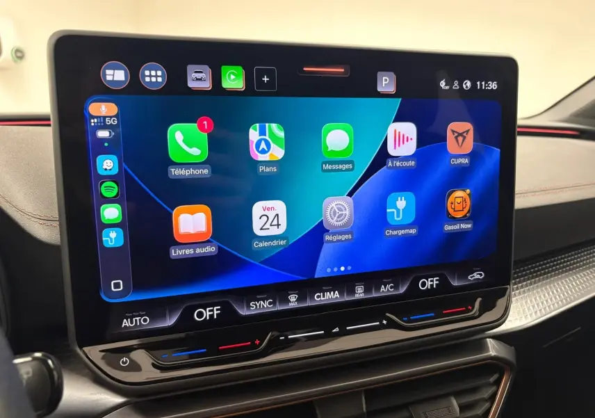 Écran tactile central de la CUPRA Leon blanc Nevada 2025 affichant des applications connectées et commandes climatisation.