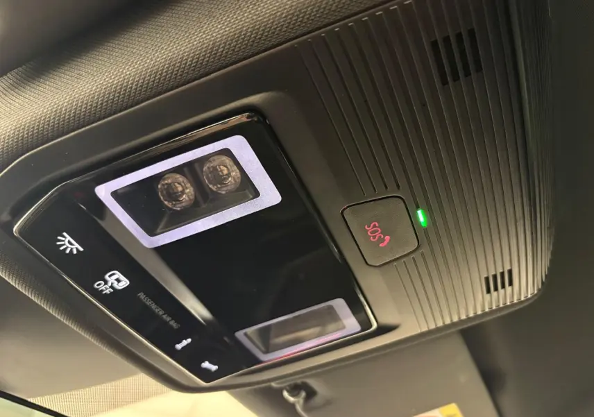 Vue en gros plan du plafonnier intérieur noir avec bouton SOS rouge et éclairage LED du CUPRA Leon Blanc Nevada 2025.