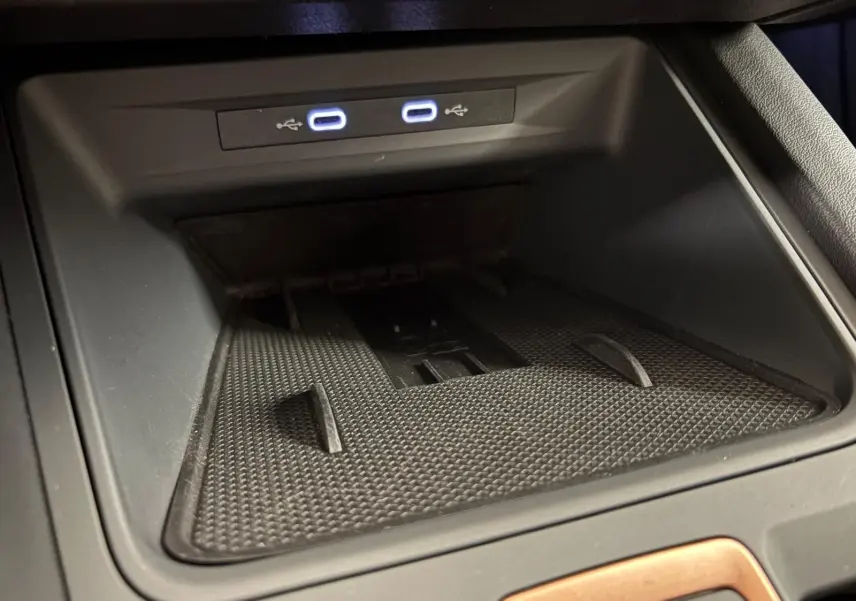 Gros plan sur la console centrale noire avec deux ports USB-C éclairés dans une CUPRA Leon Blanc Nevada 2025.