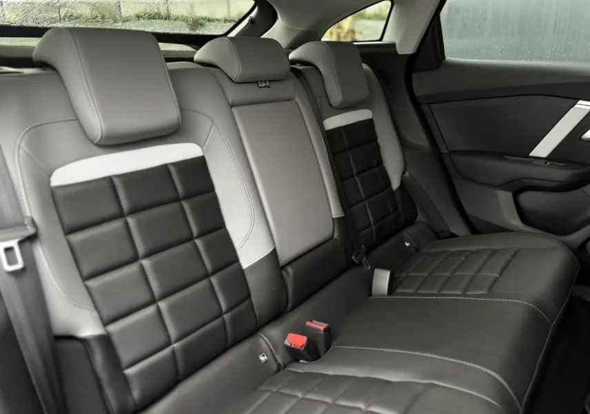 Vue intérieure de la banquette arrière bicolore noire et grise de la Citroën C4 Hybrid 2025, côté droit.