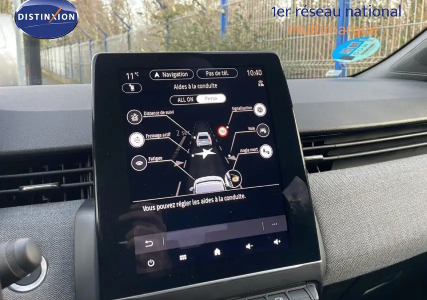 Tablette tactile centrale affichant les aides à la conduite dans une Renault Clio rouge désir métal, vue intérieure avant.