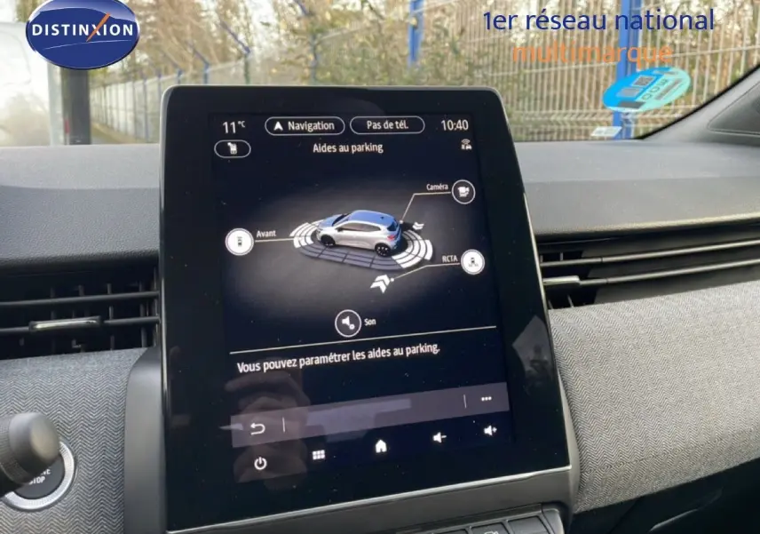 Écran tactile central de la Renault Clio 2025 affichant l'aide au parking dans un intérieur moderne.