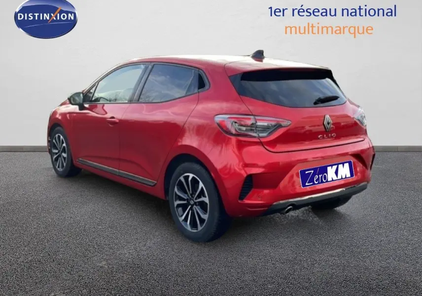 Vue 3/4 arrière droite d'une Renault Clio rouge Désir Métal avec jantes alliage et feux LED distinctifs.