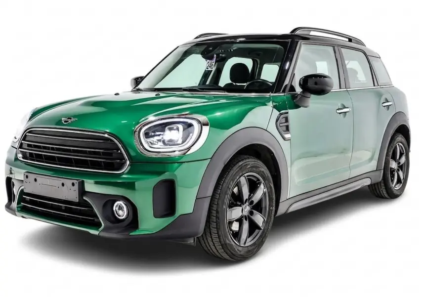 Vue 3/4 avant gauche d'une MINI Countryman vert métallisé avec toit noir et jantes noires.
