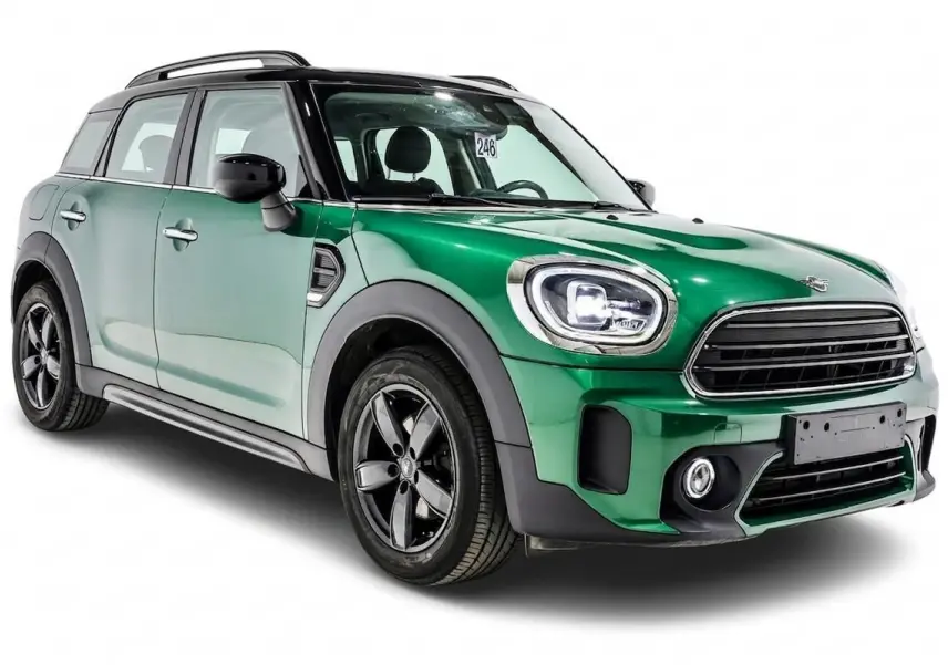 MINI Countryman vert métallisé en 3/4 avant droit, avec toit noir et jantes noires distinctives.