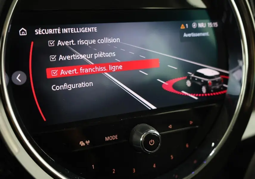 Affichage du système de sécurité intelligente sur l'écran central du MINI Countryman 2021, avec alertes de collision et franchissement de ligne.