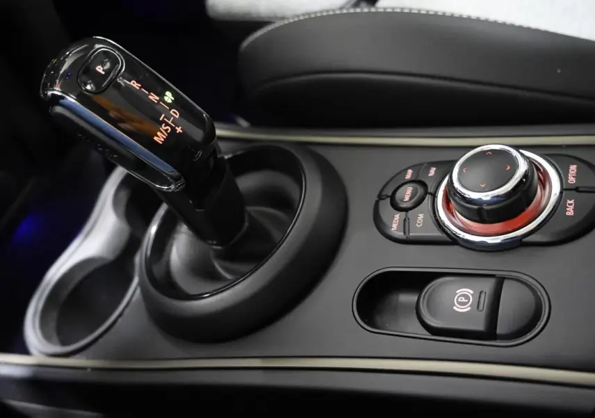 Gros plan sur la console centrale de MINI Countryman 2021, avec levier de boîte auto et commandes multimédia noires.