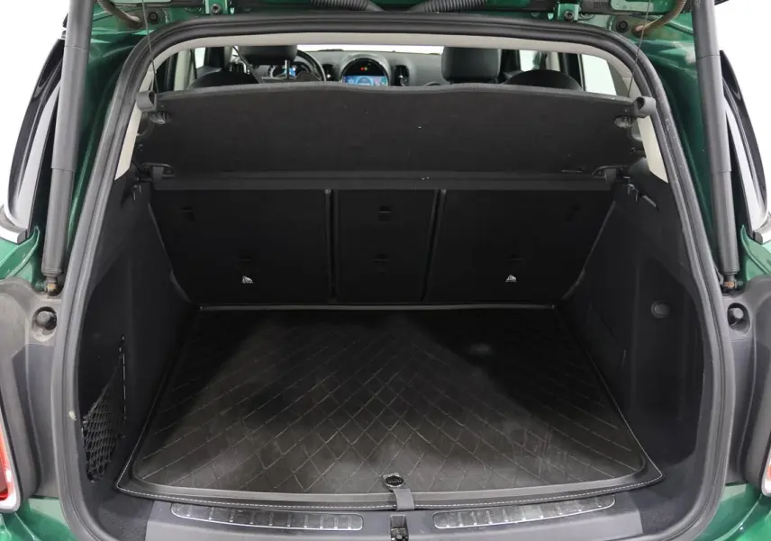 Coffre ouvert d’une MINI Countryman vert métallisé, vue arrière montrant un espace de chargement propre et spacieux.