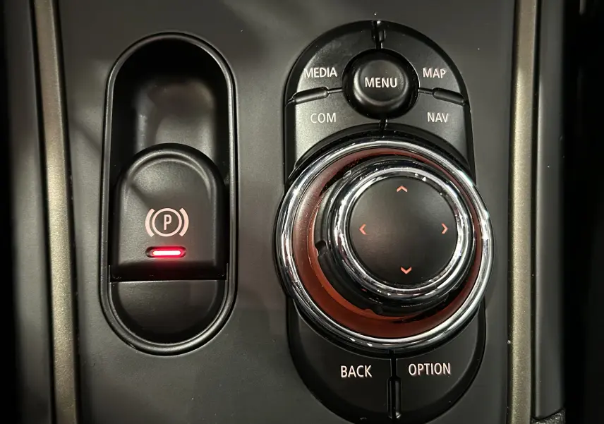 Gros plan sur la molette de commande centrale et le frein à main électrique du MINI Countryman 2021.