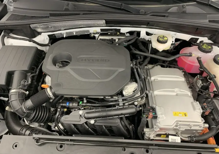 Vue rapprochée du moteur hybride du MG ZS 1.5L Hybrid+ 197CH, avec capot blanc Dover White visible autour.