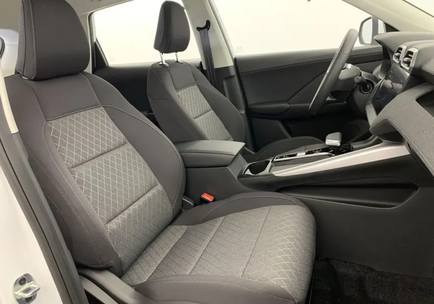 Vue intérieure côté gauche du poste de conduite du MG ZS 1.5L Hybrid+ 2026 avec sièges tissu gris et noir.