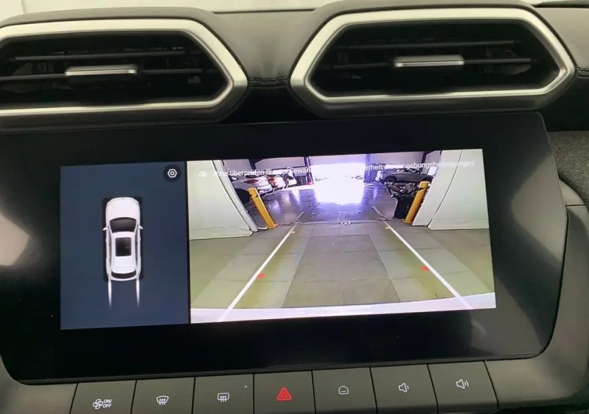 Écran central du MG ZS blanc montrant la caméra de recul avec vue arrière et affichage 3D du véhicule.