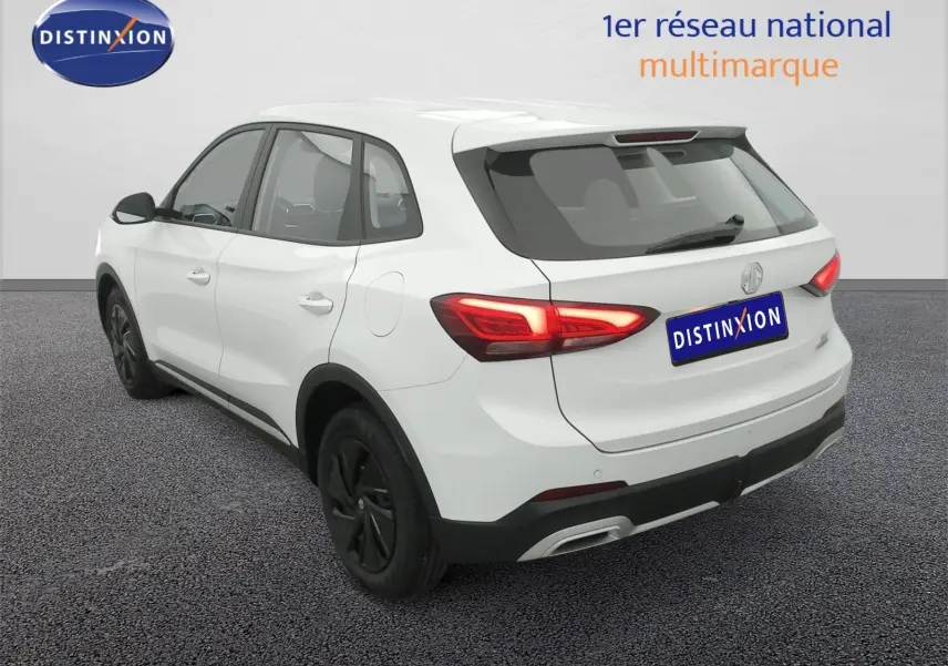 Vue 3/4 arrière droite du SUV MG ZS blanc Dover White avec feux arrière allumés et jantes noires.