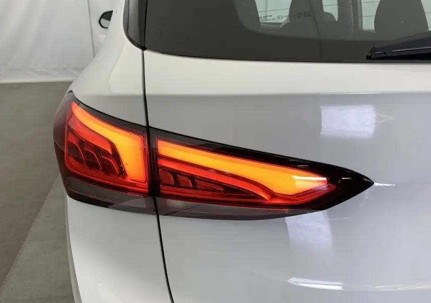 Gros plan sur le feu arrière droit rouge allumé du MG ZS blanc Dover White, vue arrière partielle.