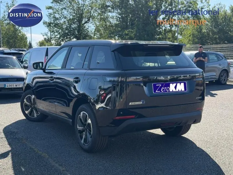 Vue 3/4 arrière droite du SUV JAECOO J5 2026 en noir Carbon Crystal Black métal avec feux arrière LED et toit panoramique.