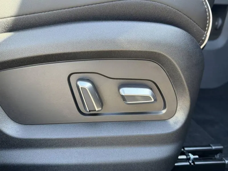Gros plan sur les commandes électriques de réglage du siège en cuir synthétique noir du JAECOO J5 Carbon Crystal Black.