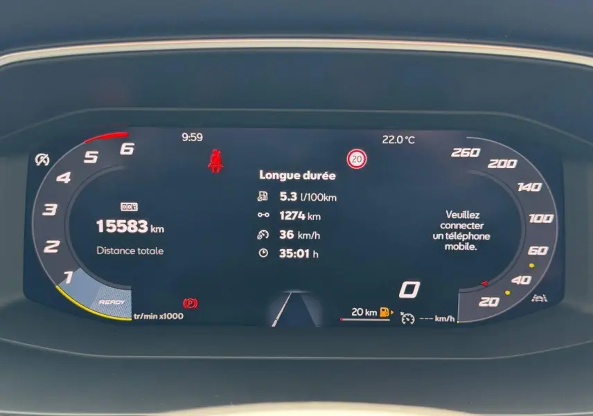 Tableau de bord numérique du SEAT Leon 2025 affichant consommation, distance, vitesse et alertes, vue frontale rapprochée.