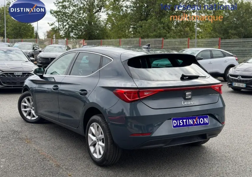 Vue 3/4 arrière droite d'une SEAT Leon gris magnétique métallisé avec feux arrière LED et jantes alu.